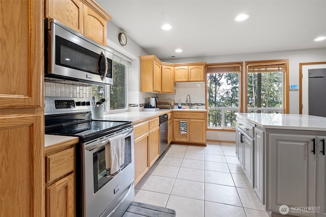 1716 7th St SE, Puyallup, WA 98372 - kitchen with backsplash, light countertops, appliances with stainless steel finishes, and a healthy amount of sunlight
