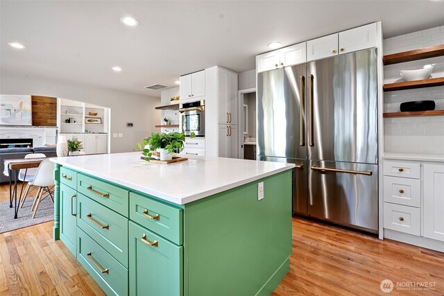 1716 7th St SE, Puyallup, WA 98372 - kitchen with light wood-type flooring, white cabinetry, open shelves, appliances with stainless steel finishes, and green cabinetry