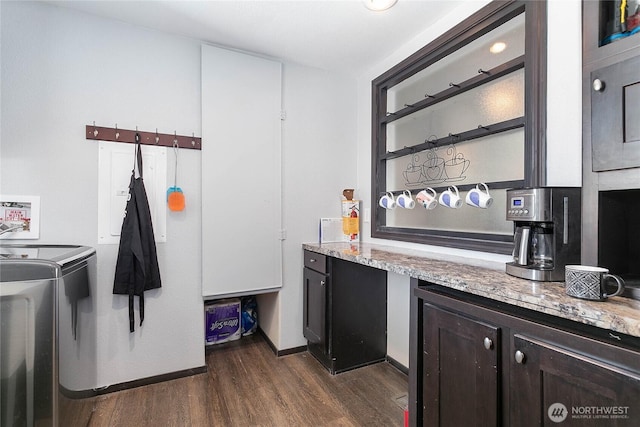interior space with washing machine and clothes dryer, laundry area, and dark wood finished floors