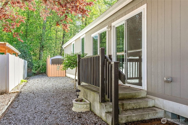 deck with fence, an outbuilding, and a shed