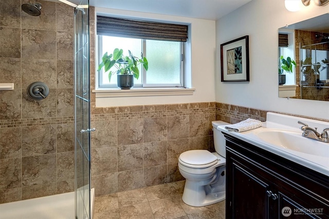 full bathroom with a shower stall, vanity, and tile walls