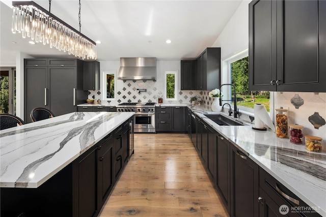 12425 318th Ave NE, Duvall, WA 98019 - kitchen featuring high end stainless steel range, a sink, wall chimney range hood, light wood finished floors, and light stone counters