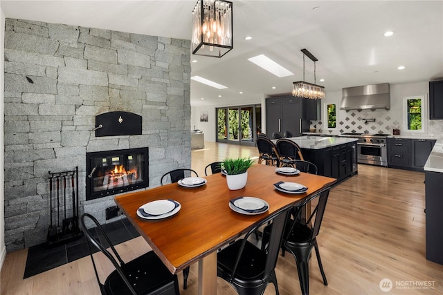 12425 318th Ave NE, Duvall, WA 98019 - dining area with a chandelier, light wood-type flooring, a stone fireplace, and recessed lighting
