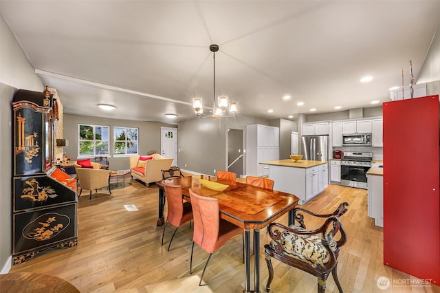 dining room with recessed lighting, an inviting chandelier, and light wood-type flooring