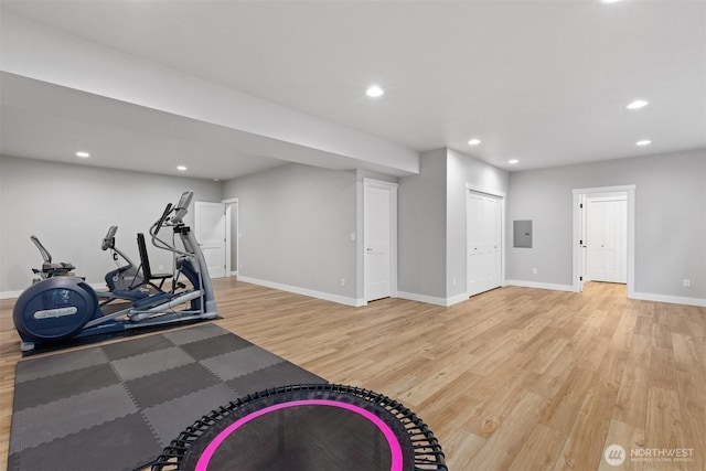 workout room featuring light wood finished floors, electric panel, baseboards, and recessed lighting
