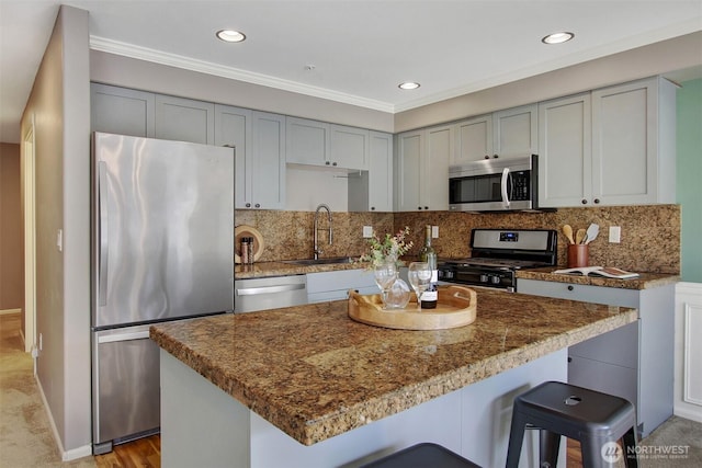 10549 Stone Ave N Unit 103, Seattle, WA 98133 - kitchen featuring appliances with stainless steel finishes, gray cabinetry, a kitchen bar, a kitchen island, and tasteful backsplash