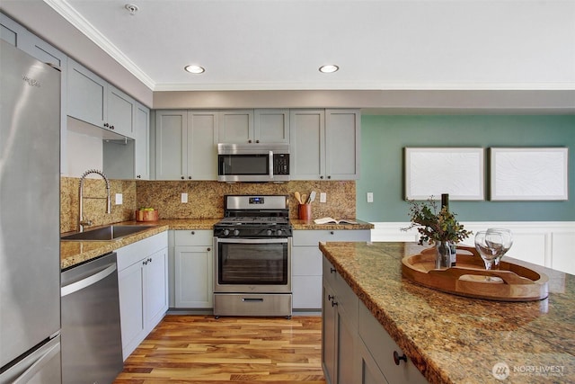 10549 Stone Ave N Unit 103, Seattle, WA 98133 - kitchen featuring stainless steel appliances, light wood-style flooring, backsplash, ornamental molding, and gray cabinets