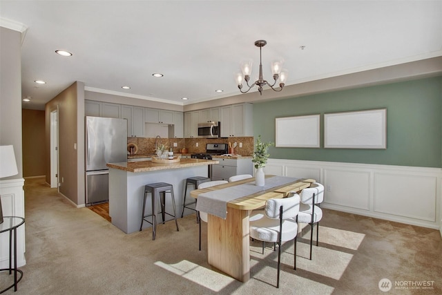 10549 Stone Ave N Unit 103, Seattle, WA 98133 - kitchen with appliances with stainless steel finishes, light carpet, gray cabinets, a chandelier, and recessed lighting