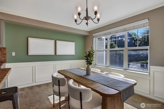 10549 Stone Ave N Unit 103, Seattle, WA 98133 - carpeted dining room featuring a decorative wall, a chandelier, wainscoting, and ornamental molding