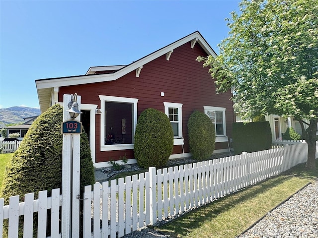 view of home's exterior with fence and a mountain view