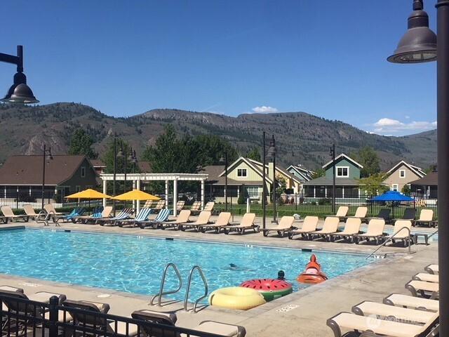 community pool with fence, a patio, and a mountain view