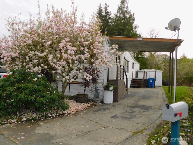 18329 32nd Ave S, Seatac, WA 98188 - view of side of property with a storage unit, an outdoor structure, a carport, and driveway