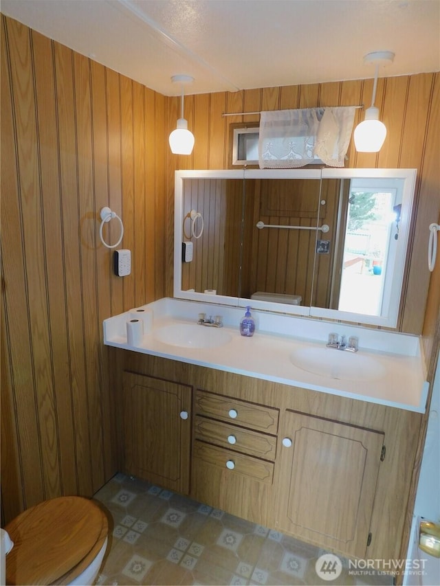 18329 32nd Ave S, Seatac, WA 98188 - bathroom with double vanity, toilet, wooden walls, and a sink