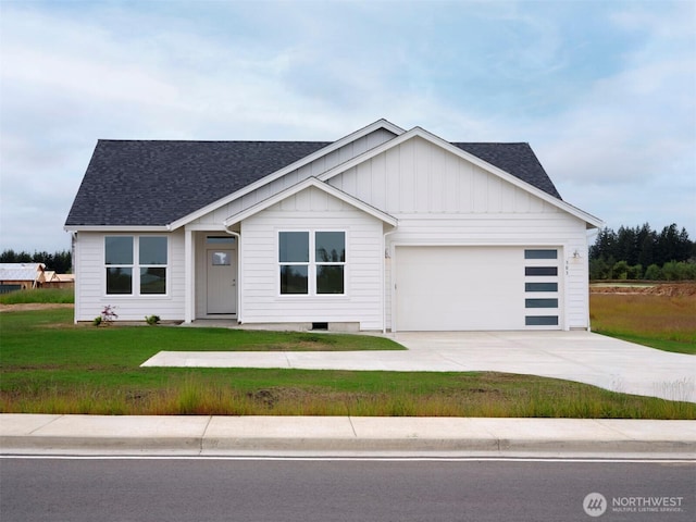 303 Kakela Rd, Winlock, WA 98596 - view of front facade with roof with shingles, concrete driveway, a front lawn, a garage, and board and batten siding