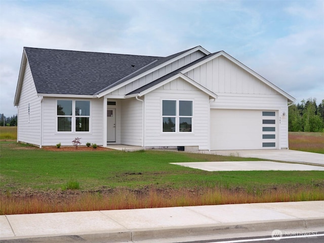 303 Kakela Rd, Winlock, WA 98596 - view of front facade with board and batten siding, an attached garage, roof with shingles, concrete driveway, and a front yard