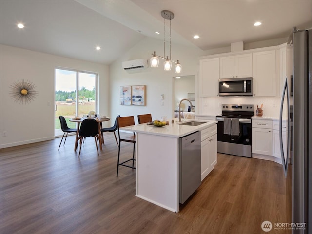 303 Kakela Rd, Winlock, WA 98596 - kitchen featuring appliances with stainless steel finishes, a sink, a wall unit AC, vaulted ceiling, and white cabinets