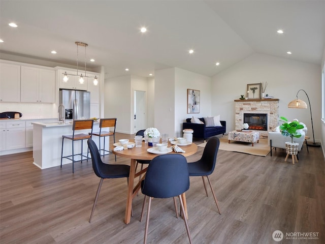 303 Kakela Rd, Winlock, WA 98596 - dining area with wood finished floors, recessed lighting, lofted ceiling, and a stone fireplace