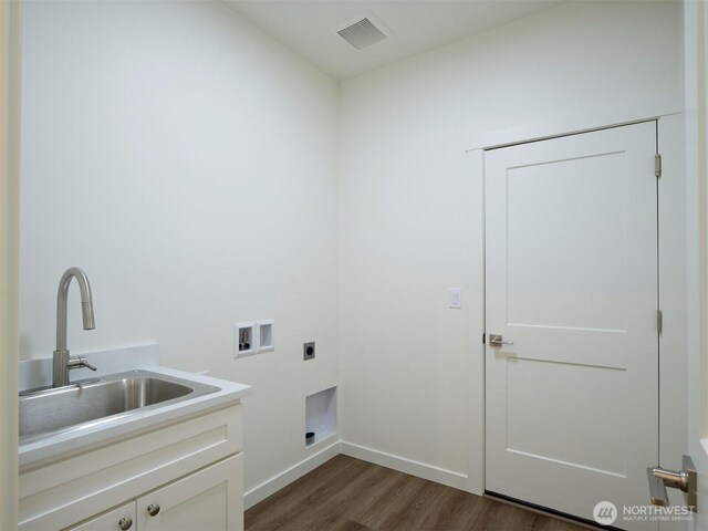 303 Kakela Rd, Winlock, WA 98596 - laundry room with cabinet space, hookup for an electric dryer, hookup for a washing machine, dark wood-style flooring, and baseboards