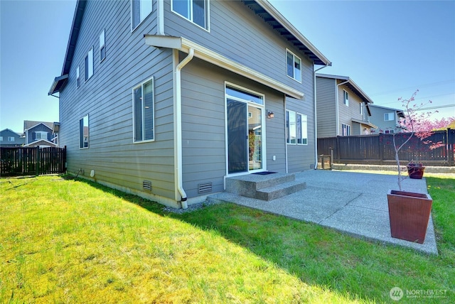 back of property with a fenced backyard and a lawn