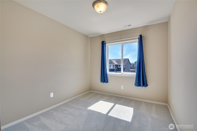 carpeted spare room with baseboards and visible vents