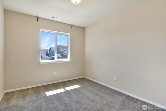 carpeted spare room with visible vents and baseboards