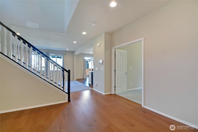 entryway with stairway, baseboards, wood finished floors, and recessed lighting