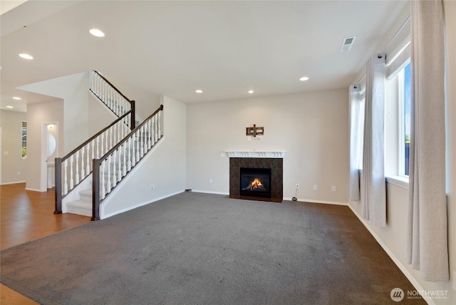 unfurnished living room with baseboards, a fireplace, recessed lighting, and stairway