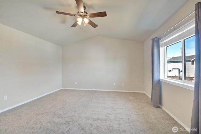 spare room featuring lofted ceiling, carpet flooring, a ceiling fan, and baseboards