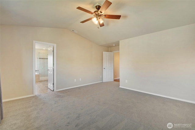 spare room featuring lofted ceiling, baseboards, carpet floors, and ceiling fan