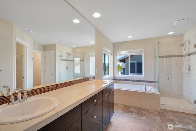 full bath featuring a shower stall, a garden tub, a sink, and a spacious closet