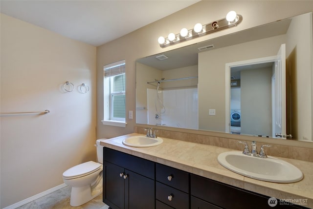 bathroom with toilet, a sink, and visible vents