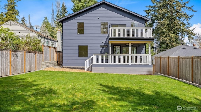 back of house featuring a balcony, a fenced backyard, and a lawn