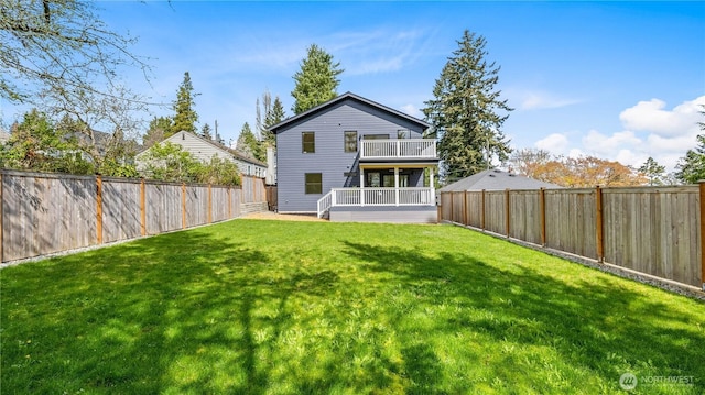 rear view of property featuring a fenced backyard and a lawn