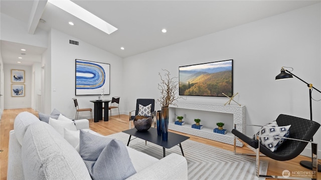 living room with light wood-type flooring, visible vents, recessed lighting, baseboards, and lofted ceiling with skylight