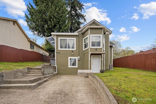 view of front of home with fence and a front lawn