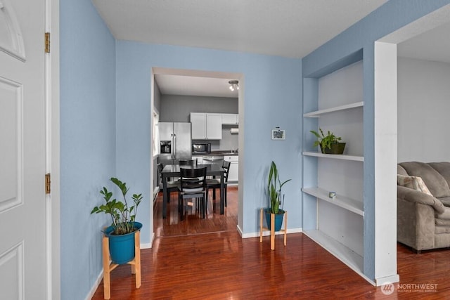 hall with built in shelves, baseboards, and dark wood finished floors