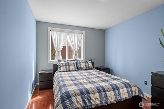 bedroom featuring baseboards and wood finished floors