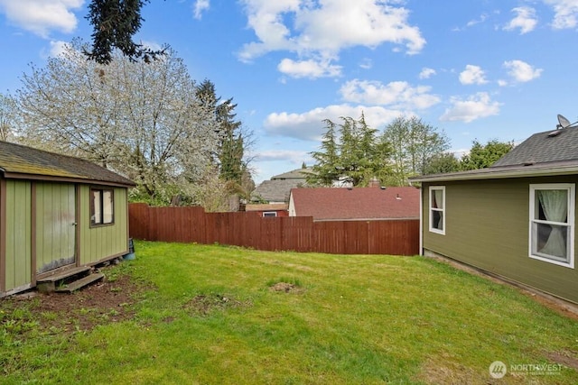 view of yard featuring an outdoor structure and fence