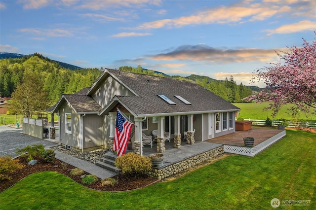 7095 N Wilde Rd, Concrete, WA 98237 - back of property at dusk featuring a yard, a shingled roof, and a deck