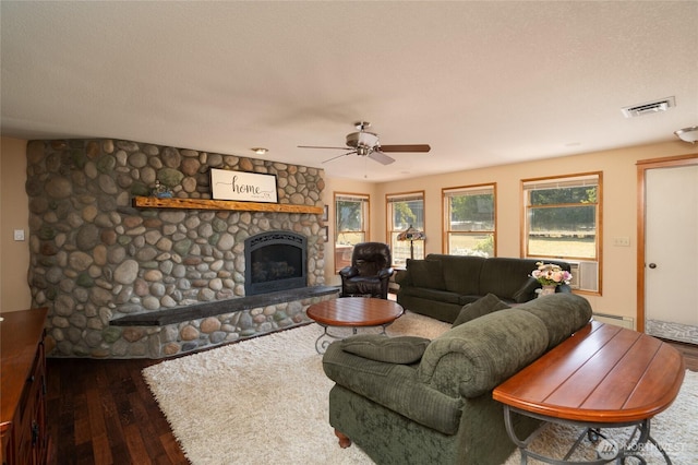 7095 N Wilde Rd, Concrete, WA 98237 - living room featuring hardwood / wood-style flooring, a stone fireplace, a ceiling fan, and baseboard heating