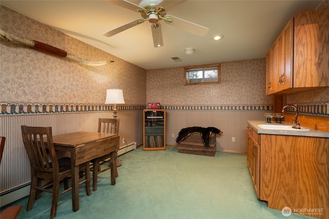 7095 N Wilde Rd, Concrete, WA 98237 - dining room featuring wallpapered walls, a baseboard heating unit, light carpet, a ceiling fan, and a wainscoted wall