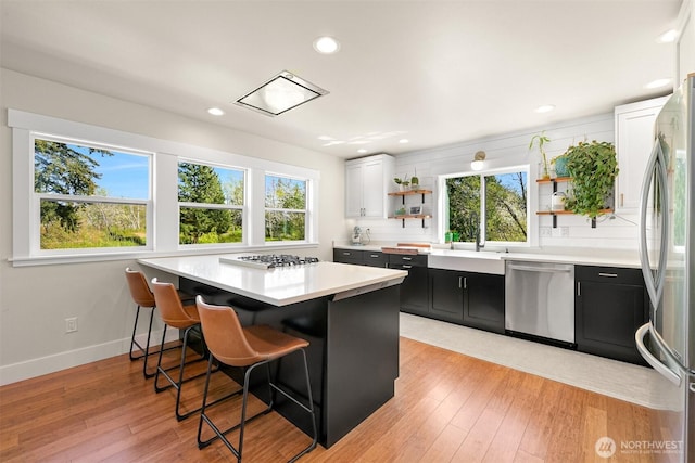 1699 Skagit St, Bellingham, WA 98226 - kitchen with dark cabinets, a healthy amount of sunlight, open shelves, and appliances with stainless steel finishes