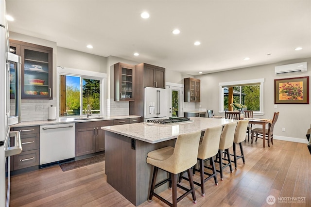 1699 Skagit St, Bellingham, WA 98226 - kitchen featuring white appliances, a wall mounted air conditioner, a center island, a sink, and decorative backsplash