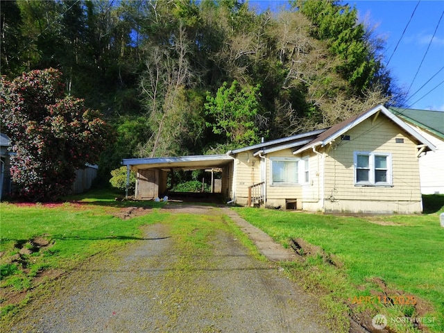 ranch-style house featuring a carport, driveway, and a front lawn