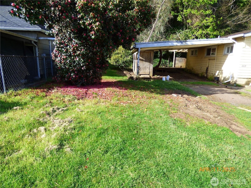 view of yard with fence and an attached carport