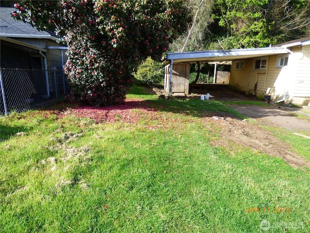 view of yard with fence and an attached carport