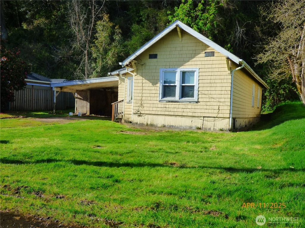 view of side of property with a yard and a carport
