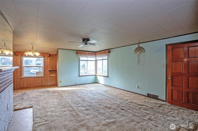 1257 S Ridgewood Ave, Tacoma, WA 98405 - unfurnished living room featuring visible vents, baseboards, carpet, wooden walls, and ceiling fan with notable chandelier