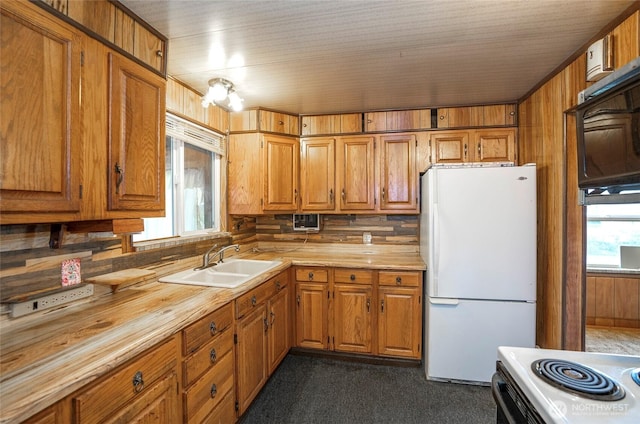 1257 S Ridgewood Ave, Tacoma, WA 98405 - kitchen featuring dark colored carpet, a sink, wooden counters, white appliances, and brown cabinets