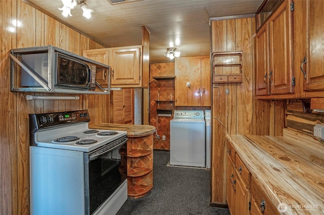 1257 S Ridgewood Ave, Tacoma, WA 98405 - kitchen featuring dark colored carpet, wooden walls, brown cabinetry, white range with electric stovetop, and washer and dryer